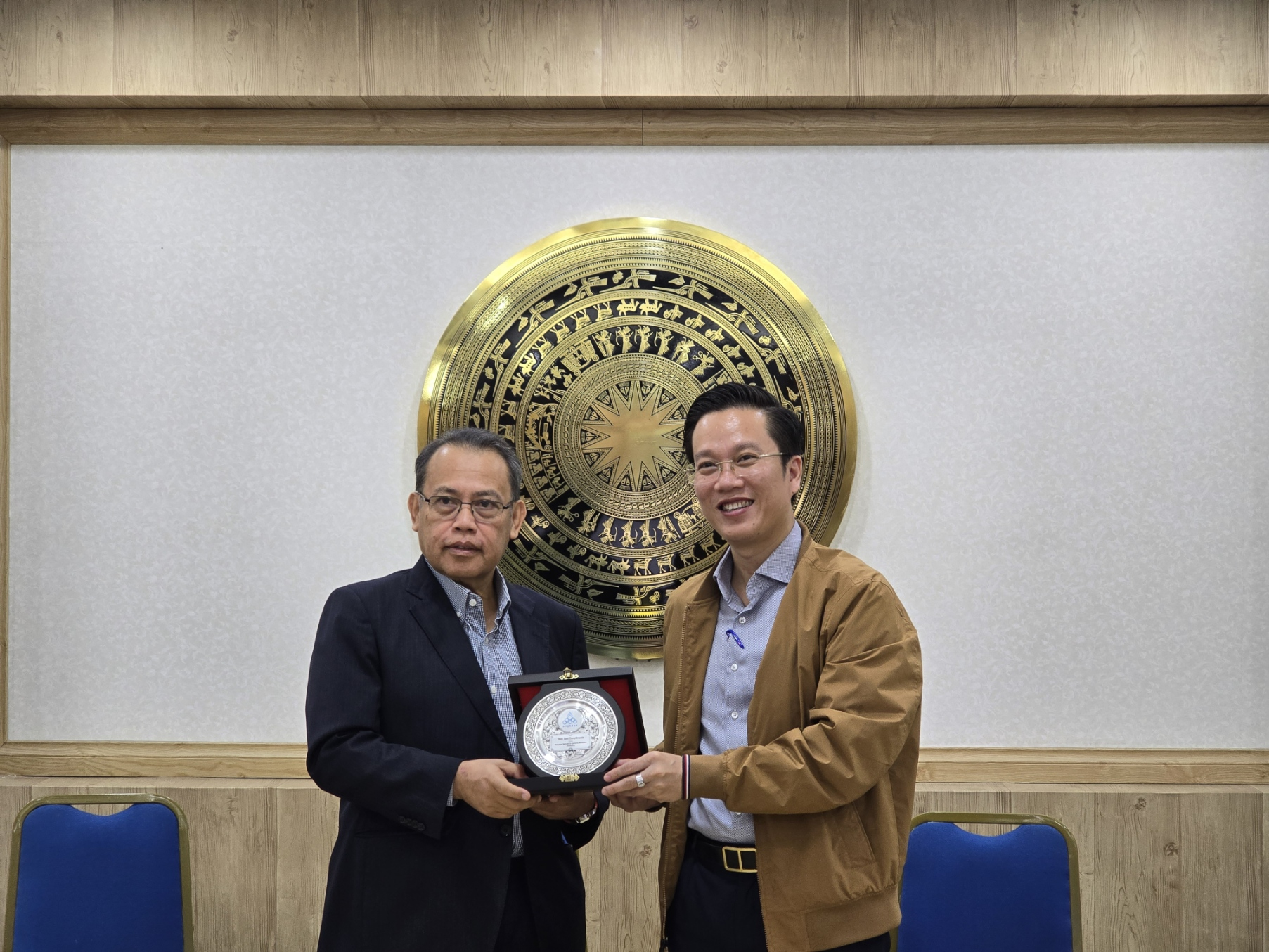 Two men holding a clock

Description automatically generated